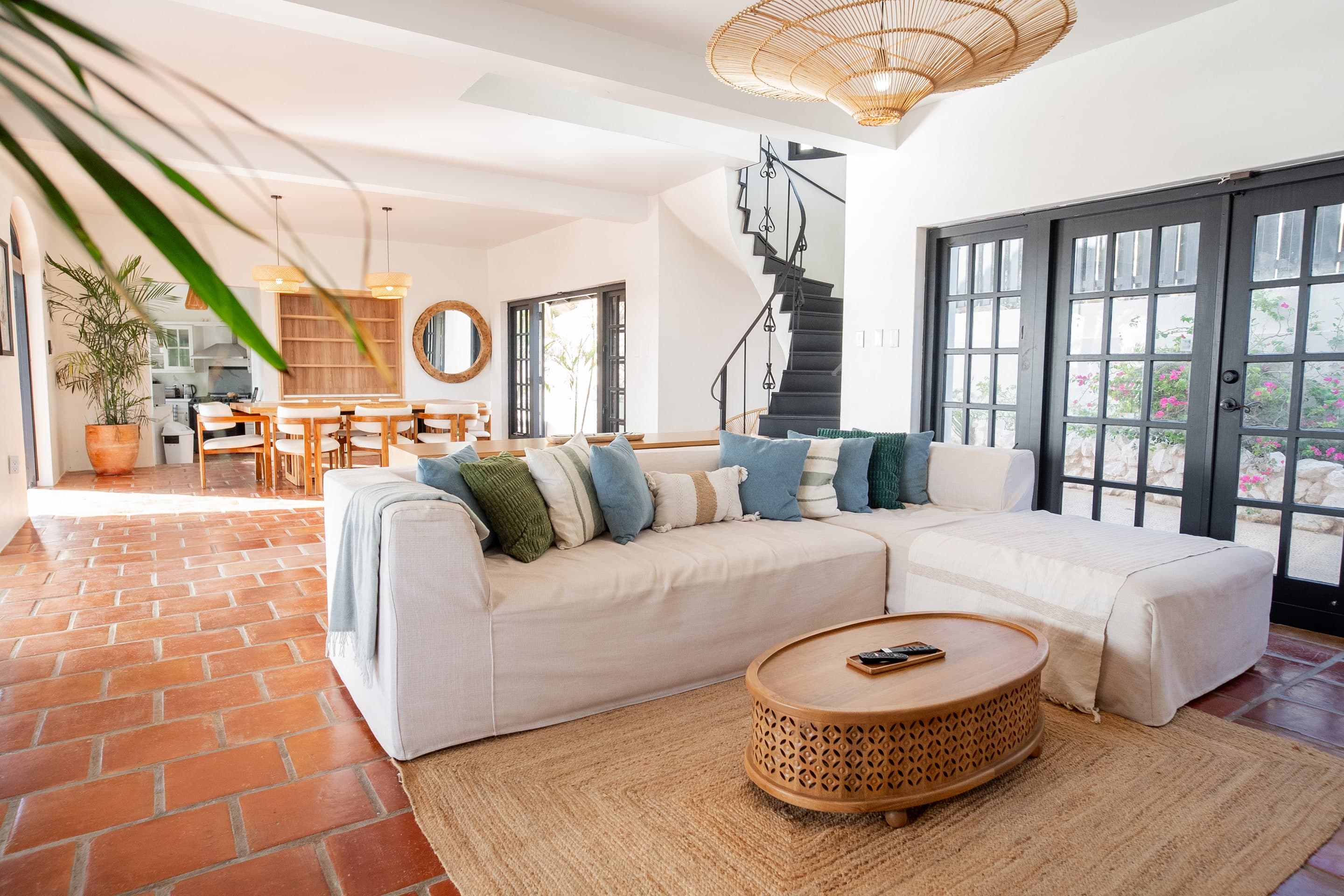 Open-plan living room at The Villa Elizabeth with terracotta floors and charcoal French doors